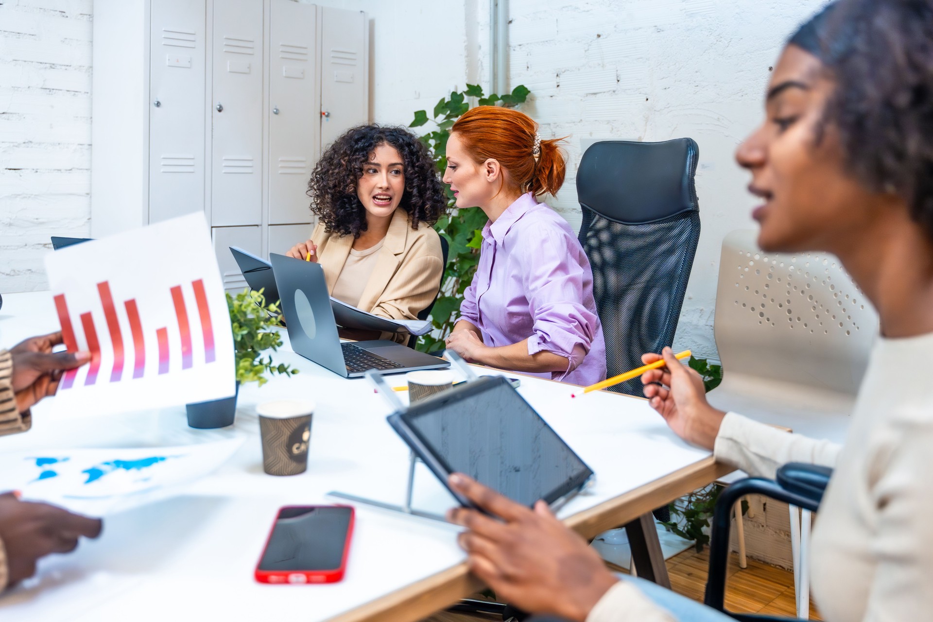 Young diverse people working in coworking space analyzing data