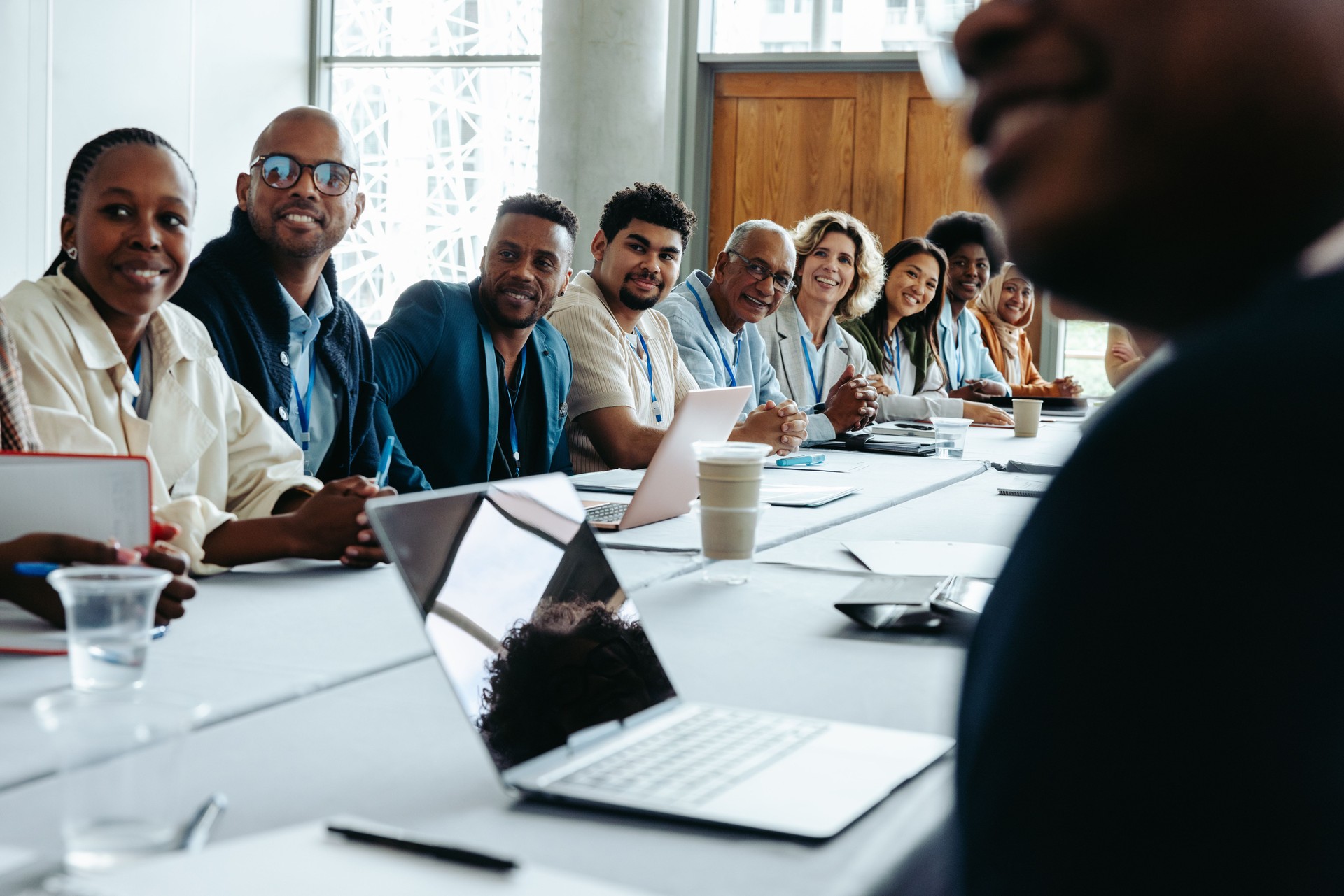 Diverse group of colleagues in a business meeting at the office, seated around a large conference table